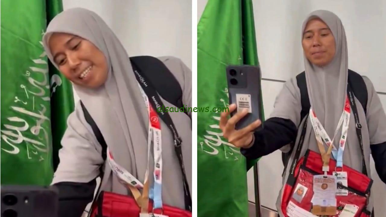 حاجة ماليزية تلتقط سيلفي مع العلم السعودي في مطار كوالالمبور قبل الحج
